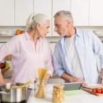 Angry mature man standing near mature serious woman at kitchen